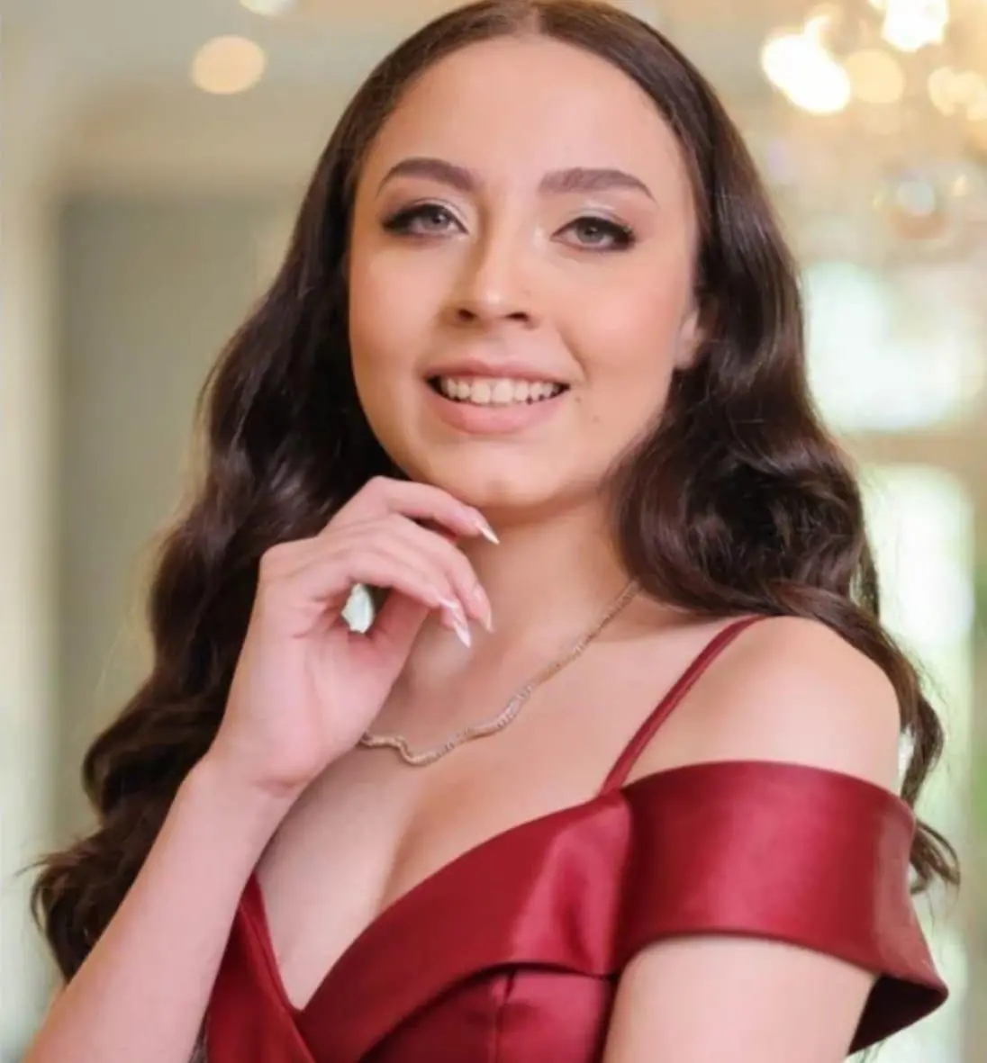 Imagem mostra a ex-ginasta rítmica Isabelle Marciniak, vestida com roupa de festa e com a mão no queixo. Foto usada em matéria que informa o que aconteceu com a atleta.