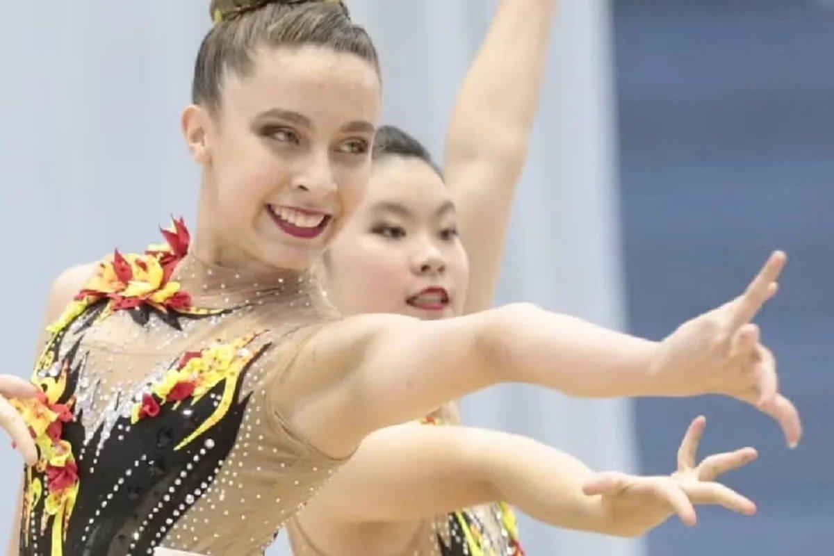 Imagem mostra a ginasta Isabelle Marciniack sorridente em apresentação. Foto usada em matéria que explica o que aconteceu com a atleta.