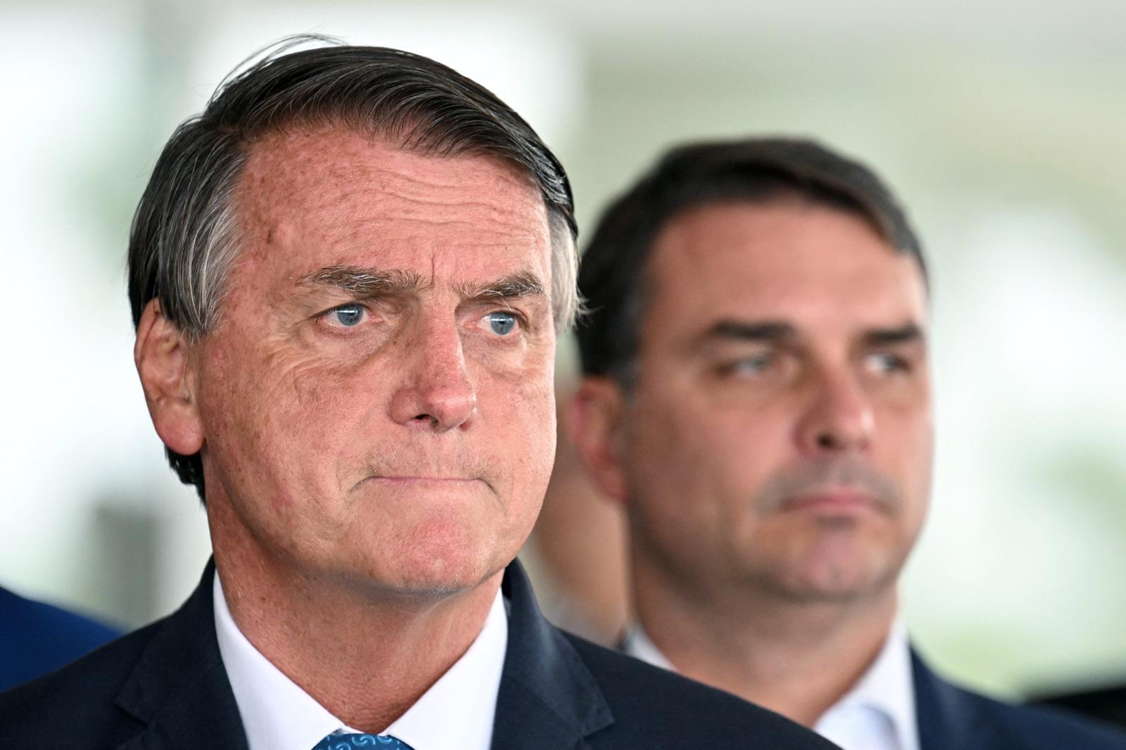 Foto que contém Jair Bolsonaro e Flávio Bolsonaro.