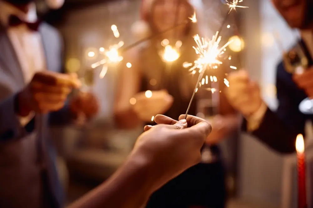 Celebrando uma ocasião especial com amigos, segurando esp-redis e brindando com bebidas, em ambiente festivo e alegre.