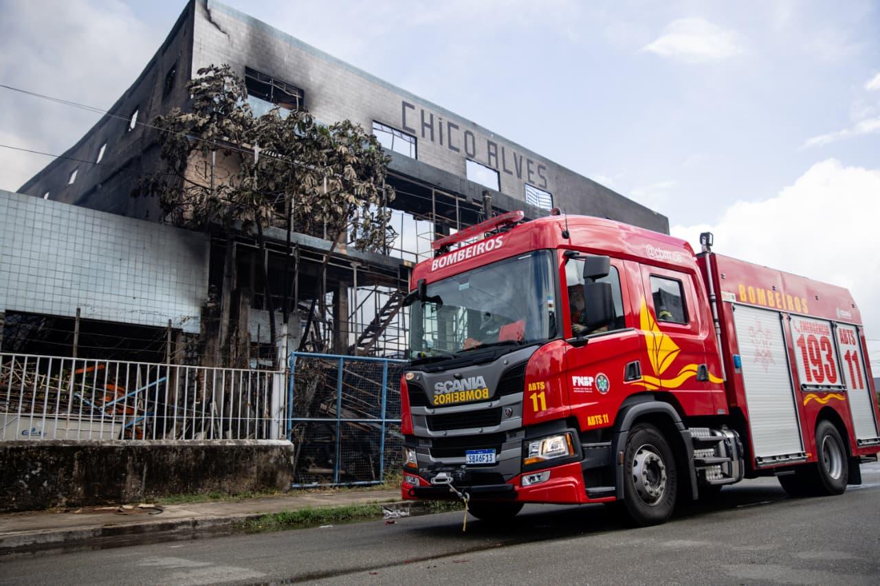 Imagem mostra viatura do corpo de bombeiros estacionada em frente à sucata do Chico Alves, em Fortaleza. Prédio da loja apresenta marcas de fumaça e fogo devido ao incêndio registrado no local.