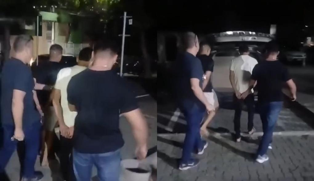 Montagem com dois frames de um vídeo em que dois suspeitos são capturados e colocados no carro da polícia.