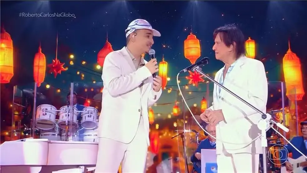Foto que contém os cantores João Gomes e Roberto Carlos.