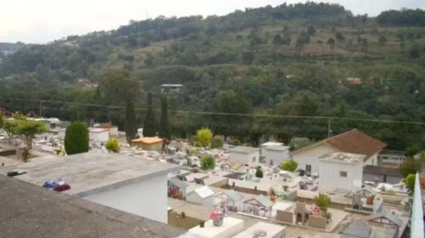 Imagem mostra cemitério com lápides brancas próximo de uma montanha na cidade de Capinzal, em Santa Catarina.