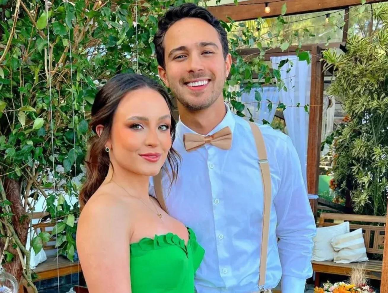 Larissa Manoela de vestido verde, cabelo com penteado e tranças pequenas, enquanto André Luiz Frambach está com camisa de botões branca.