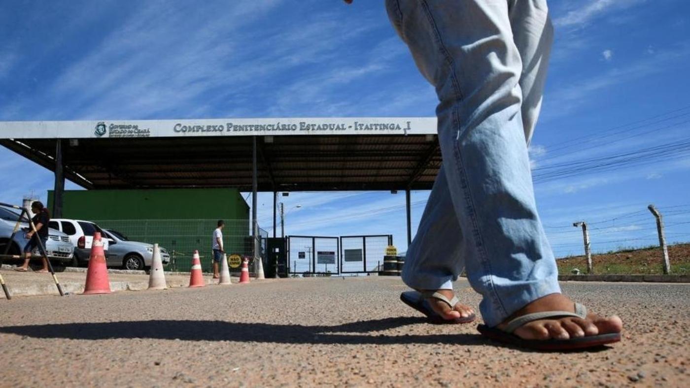 A imagem mostra pernas de uma pessoa, andando no sentido oposto ao Complexo Penitenciário Estadual Itaitinga II.