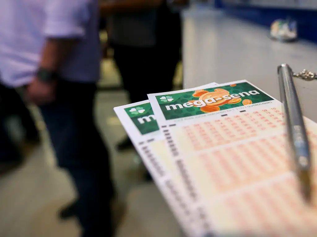 cartela impressa para escolha de número da mega-sena, com caneta prata ao lado.