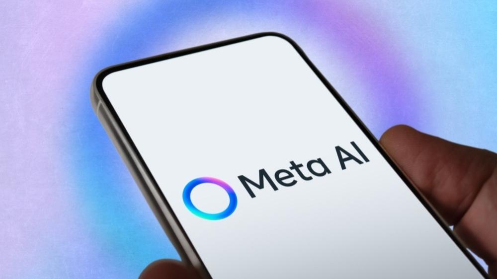 Mão segura celular aberto na página Meta AI.