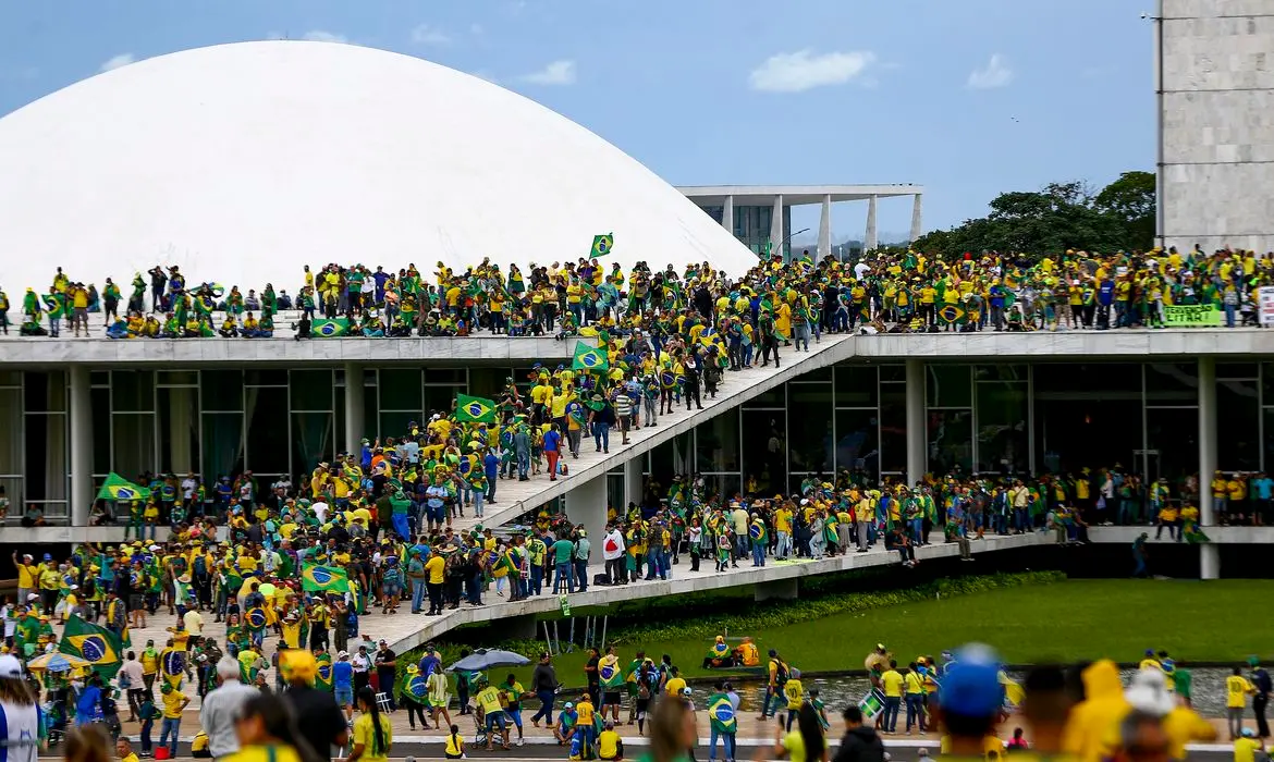Multidão com roupas verde e amarelo invadem prédio do Congresso Nacional em 8 de janeiro.