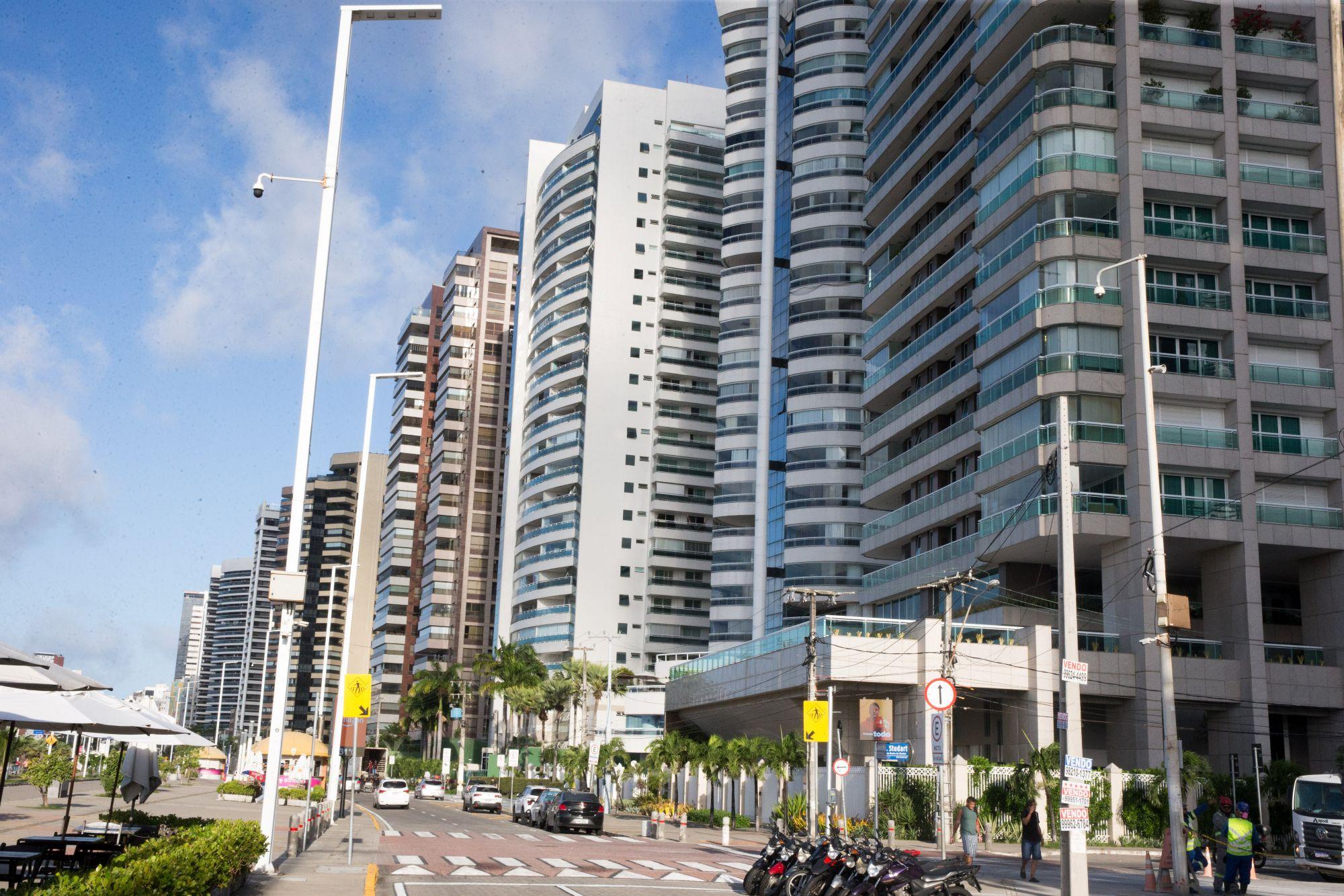 Paisagem urbana da Beira-Mar de Fortaleza com inúmeros prédios altos e espigões sob um céu claro, destacando a arquitetura vertical e a infraestrutura de rua. Imagem ilustra reportagem sobre o IPTU 2026.