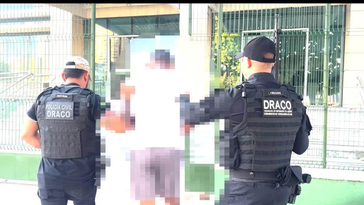 foto homem preso draco, organizacao criminosa, policiais acompanhando o suspeito.