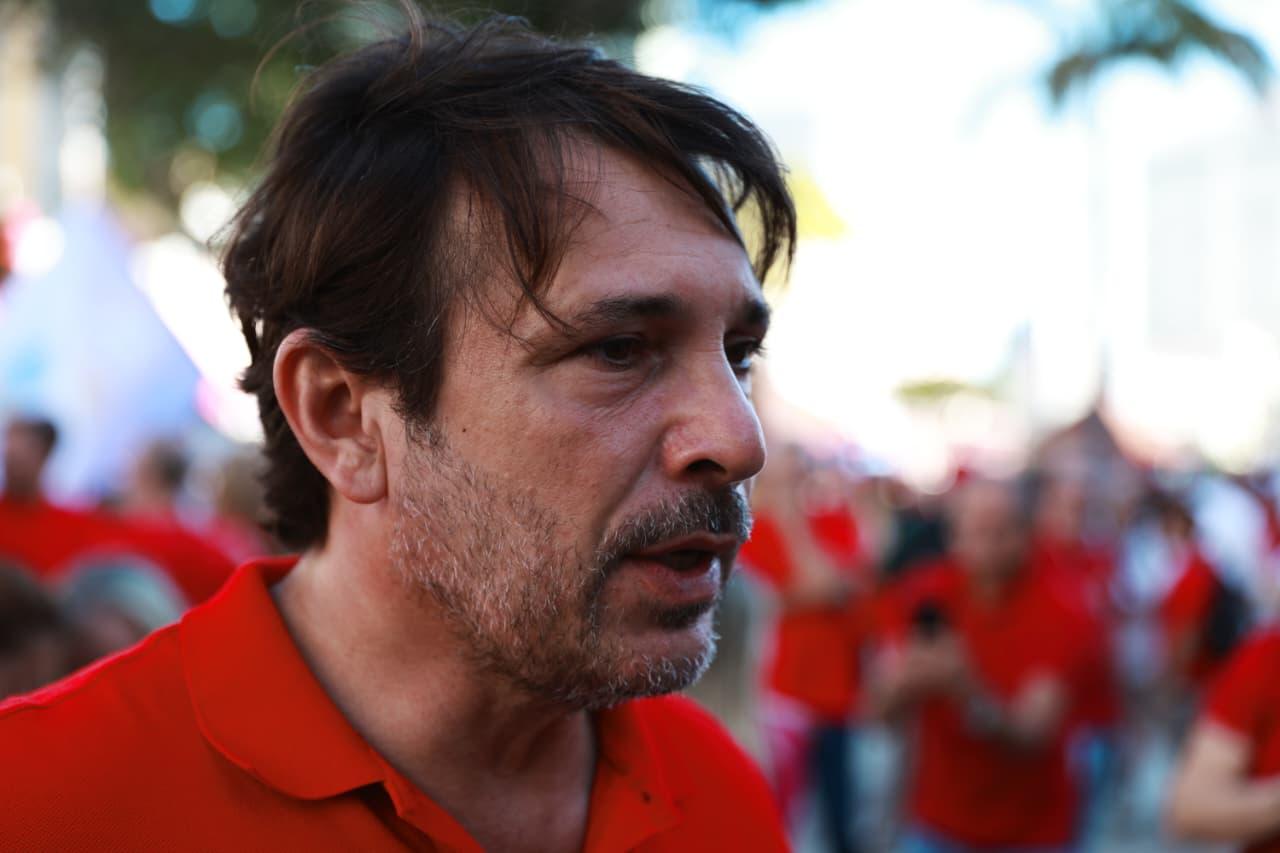 Guilherme Sampaio durante ato na PRaça do Ferreira. Ele veste uma camisa polo vermelha.