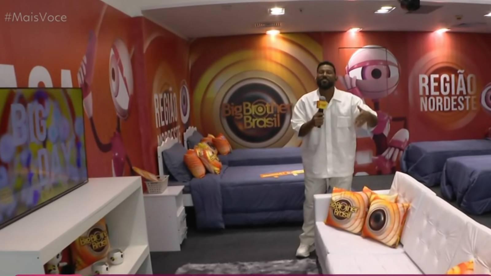 Imagem mostra repórter da TV Globo mostrando interior da casa de vidro instalada em Salvador, Bahia, na região Nordeste.