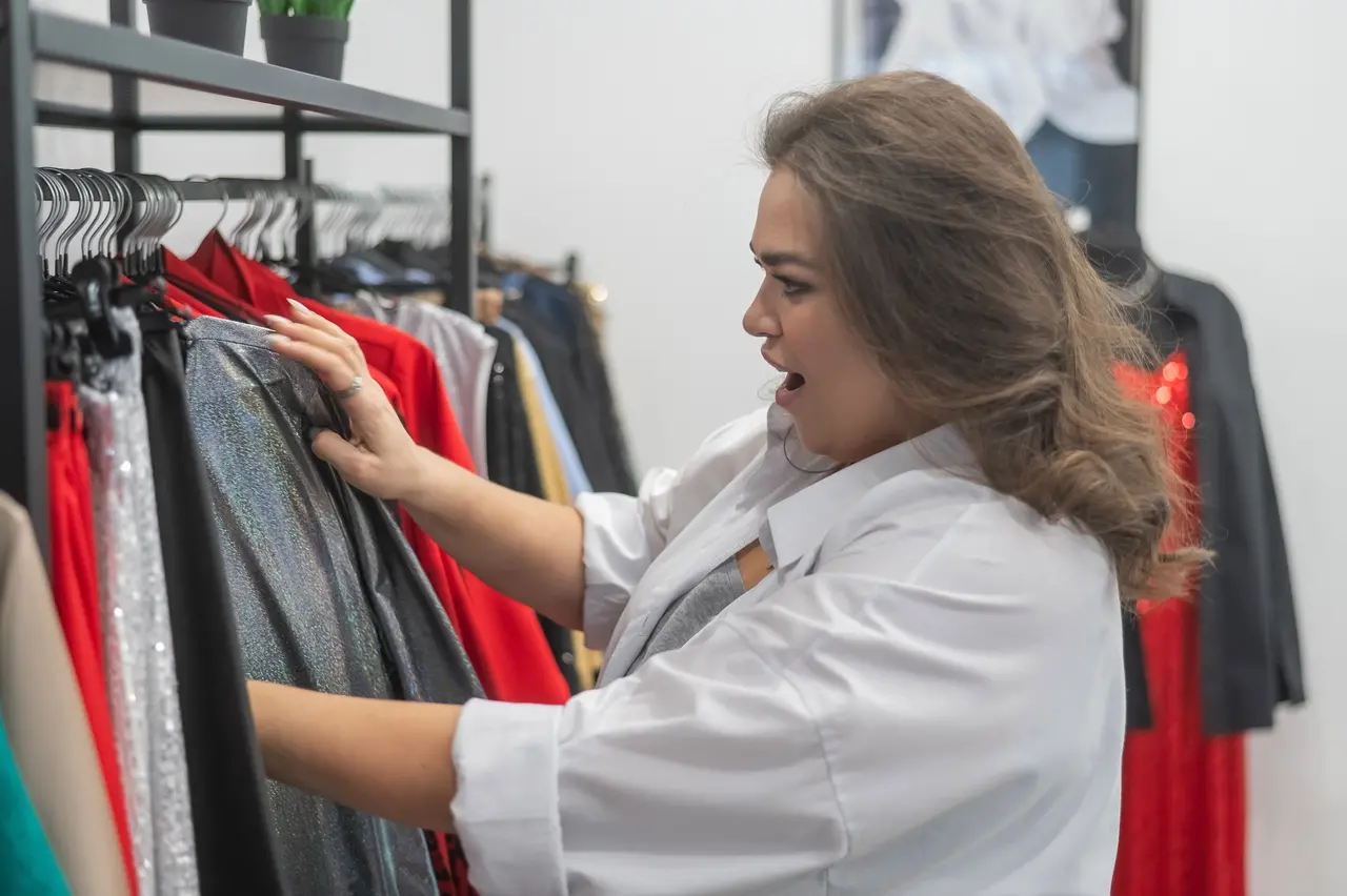 imagem mostra mulher gorda procurando roupas em uma loja.