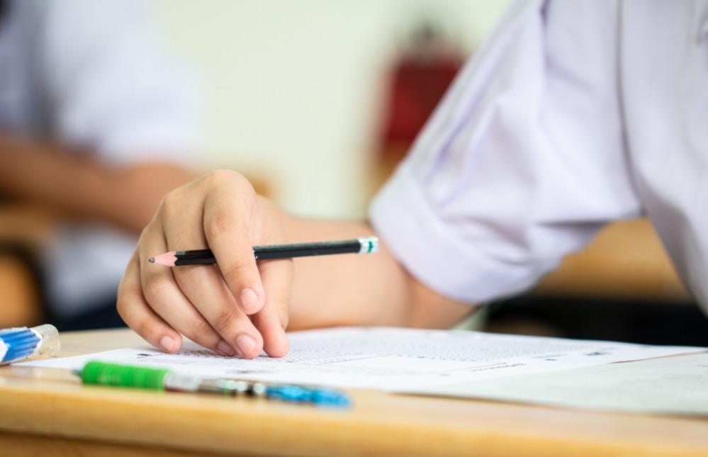 Estudante em mesa de sala de aula.