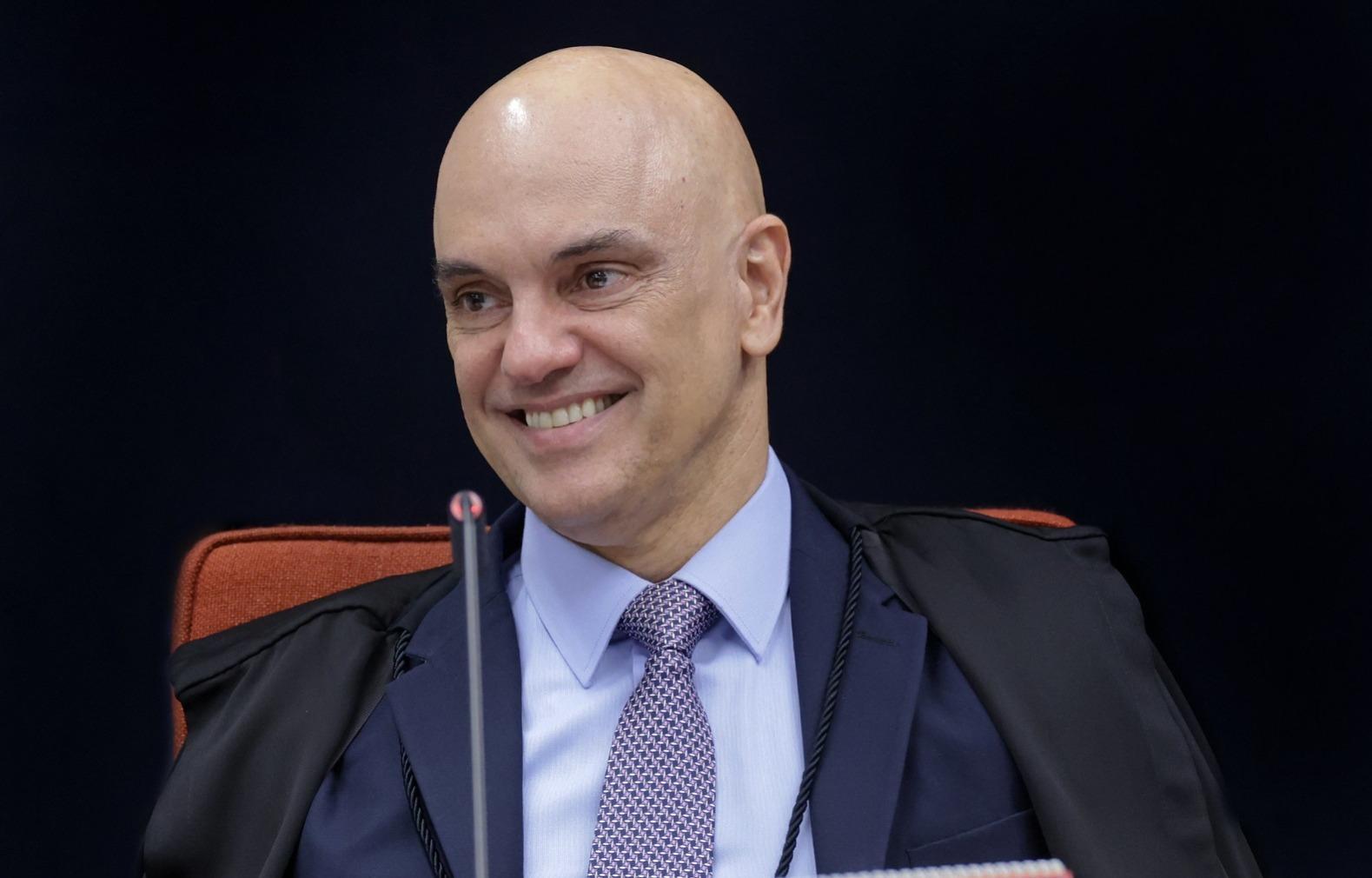 Alexandre de Moraes sorrindo no plenário no STF. Ele é um homem de meia-idade, branco e careca. Imagem usada em matéria sobre ministro assumir lugar de Fachin durante férias.