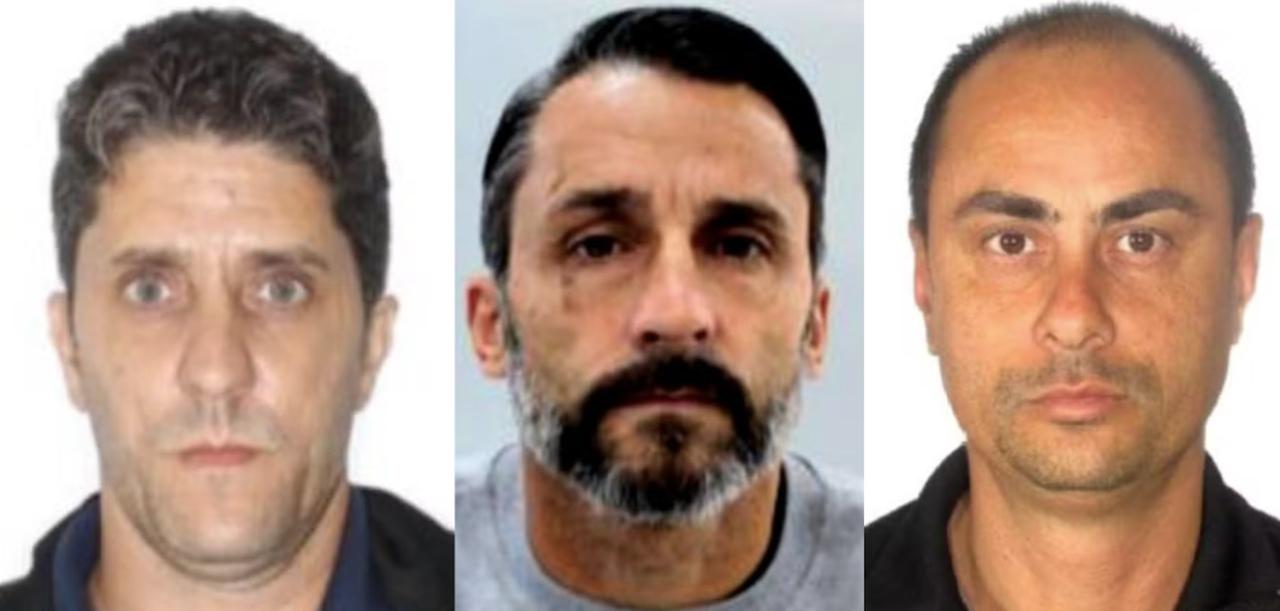 Três homens em foto de registro policial. À esquerda, homem branco de cabelos castanhos e olhos claros. Ao centro, homem branco com cabelo preto, bigode preto e barba grisalha. À direita, homem pardo com cabelo ralo e castanho.