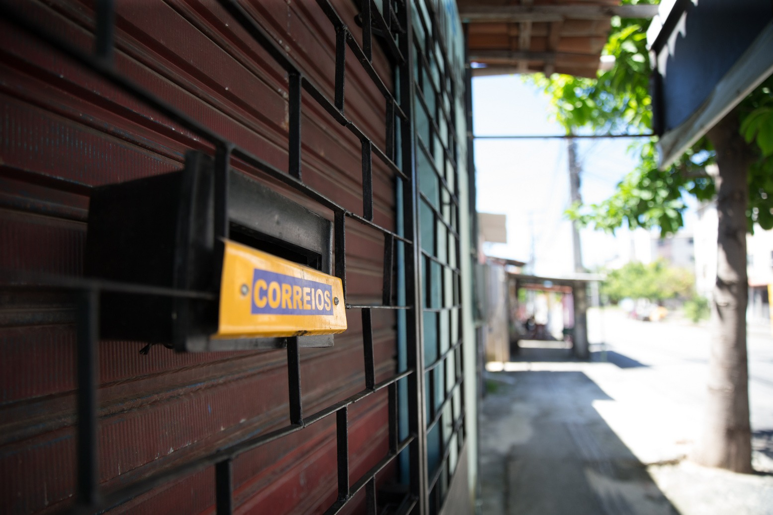 Foto que contém uma caixa de correio em estabelecimento comercial.