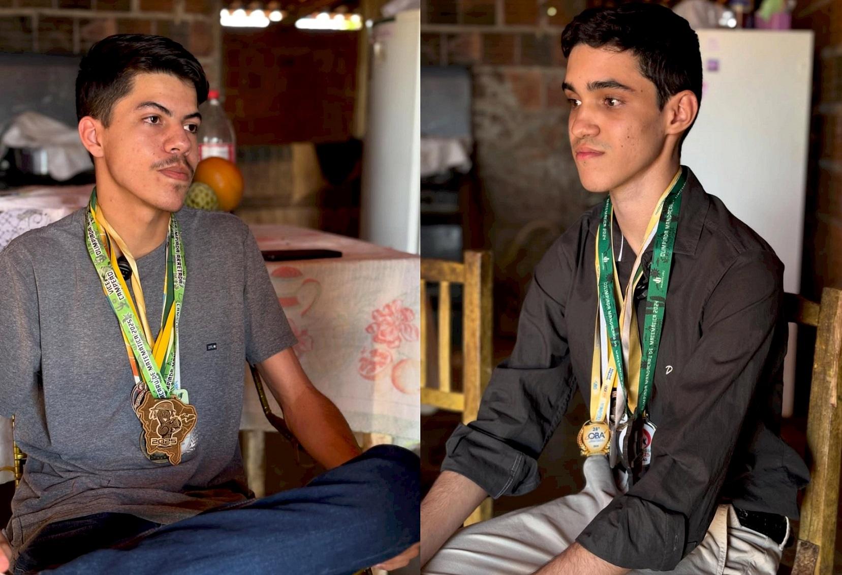Imagem de dois rapazes jovens, Davi à esquerda e Willyan à direita, um usando uma camiseta cinza e o outro uma camisa escura, ambos exibindo medalhas penduradas no pescoço, em um cenário de casa do interior simples.