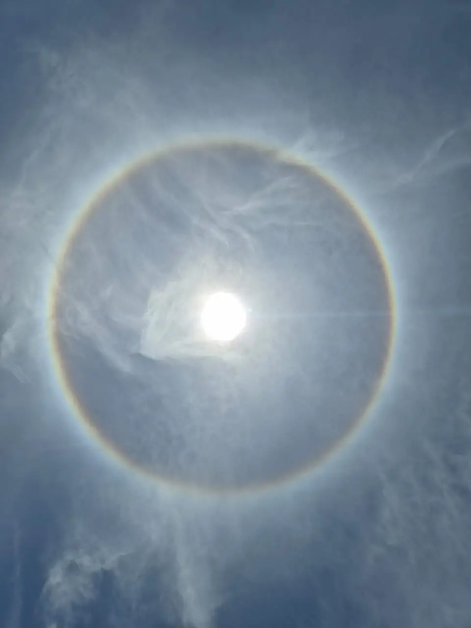 Círculo colorido similar ao arco-íris ao redor do sol.