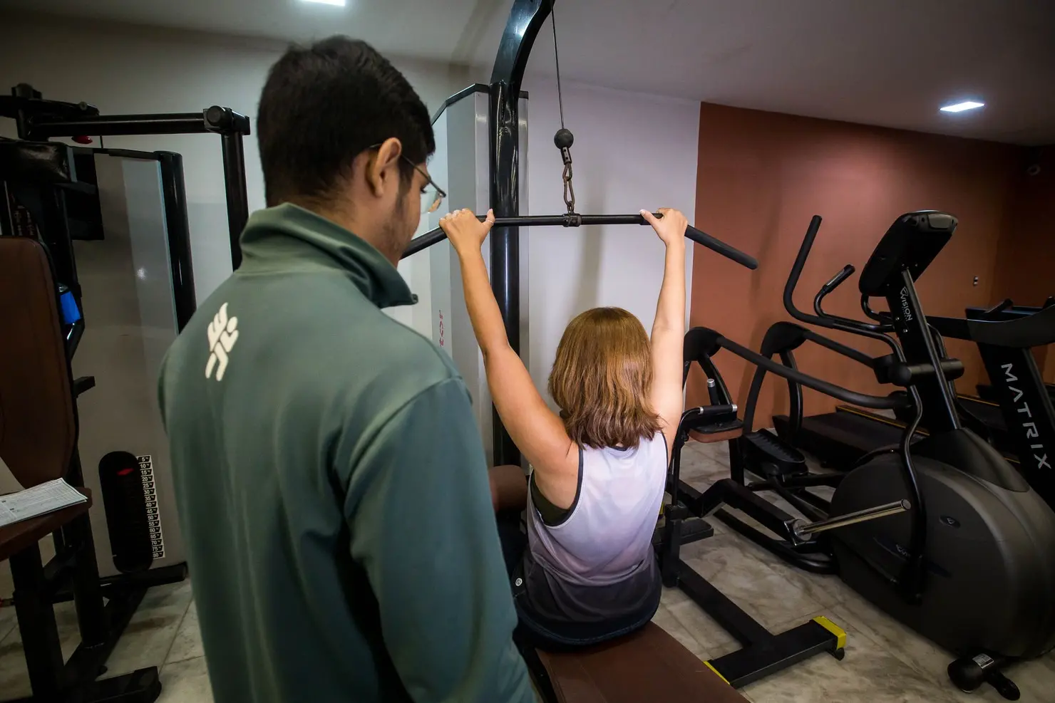 Foto que contém personal trainer e aluna em academia em Fortaleza.