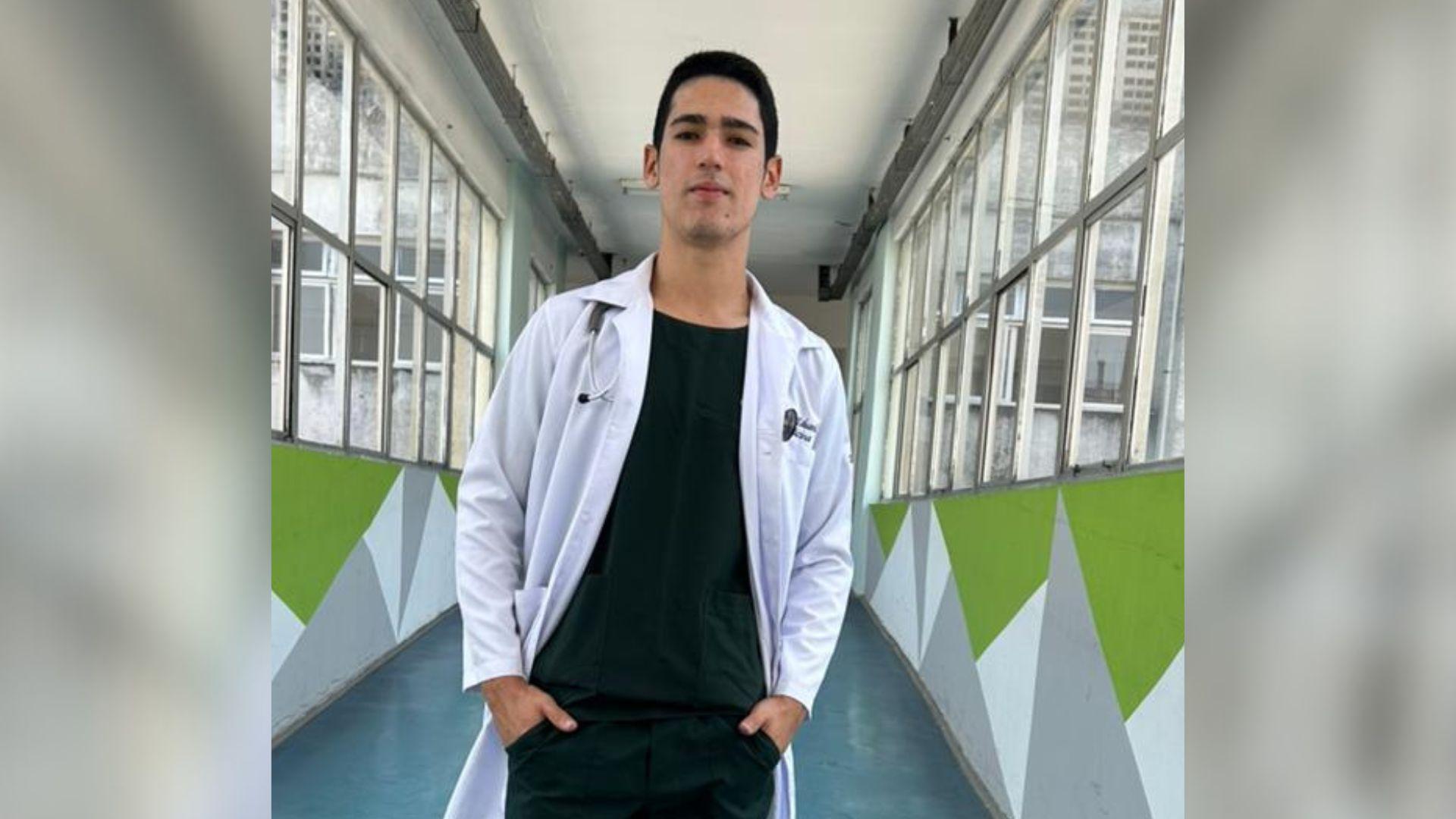 Jovem estudante de medicina, e primeiro cearense a tirar nota mil na redação do enem em 2025, de jaleco branco na passarela de hospital, representando a palavra-chave saúde e medicina com ambiente moderno e iluminado.