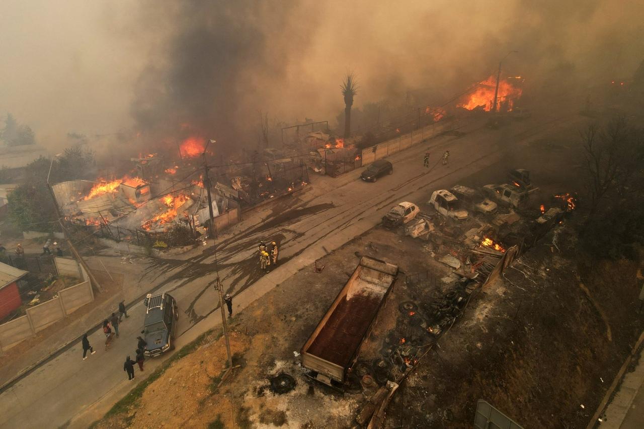 Vista aérea mostra fumaça e chamas saindo de casas atingidas por incêndio florestal em Concepción, Chile, em 18 de janeiro de 2026.