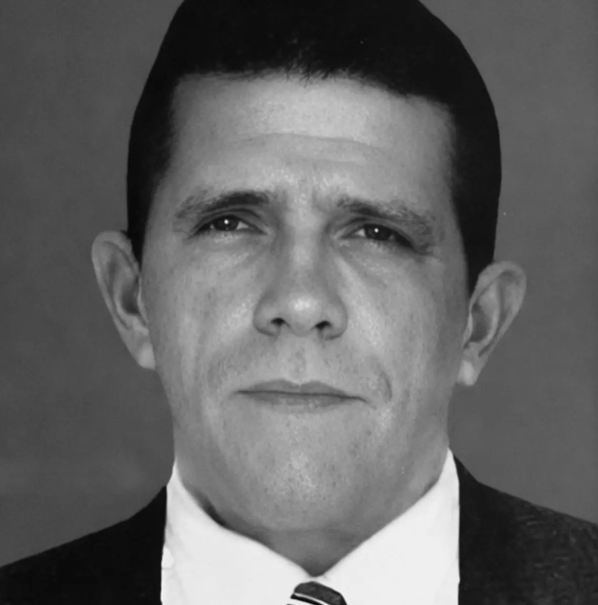 Foto em preto e branco do ex-prefeito Roberto Girão, um homem de cabelo preto curto. Na imagem, ele está de terno e camisa social branca com gravata.