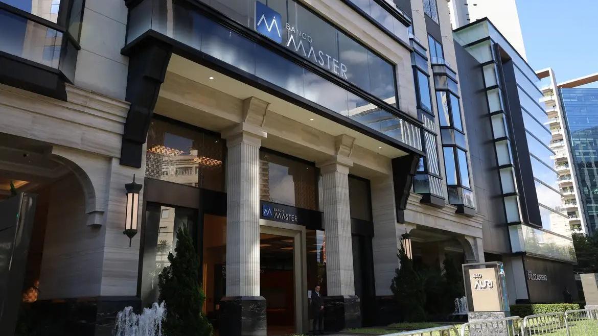 Entrada principal do edifício Master, com fachada de pedra clara, grandes janelas de vidro e colunas clássicas.