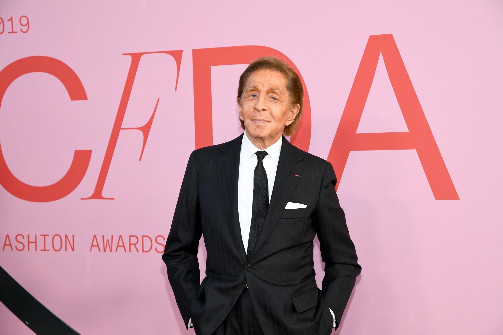 Valentino chegando a um desfile. Imagem usada em matéria sobre quem foi o estilista e sobre sua trajetória profissional no mundo da moda.