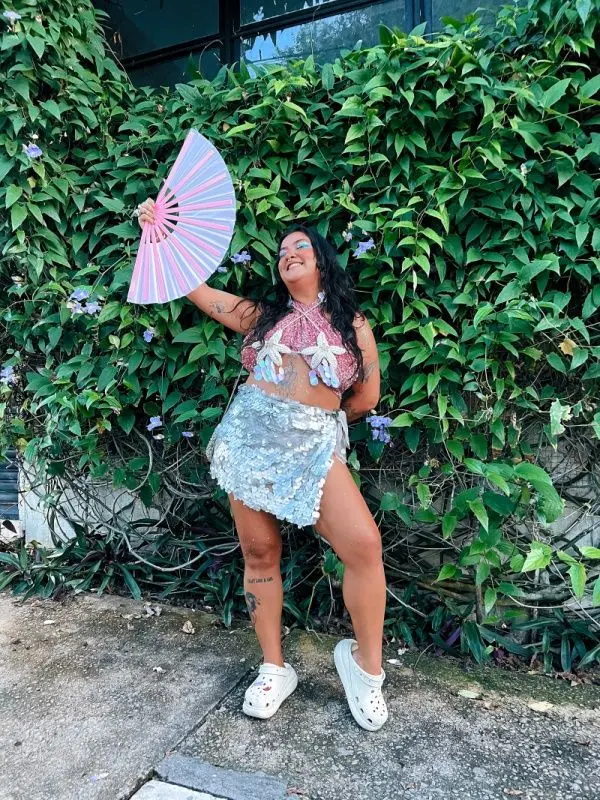 Marissa Pimenta sorrindo com um leque na mão.