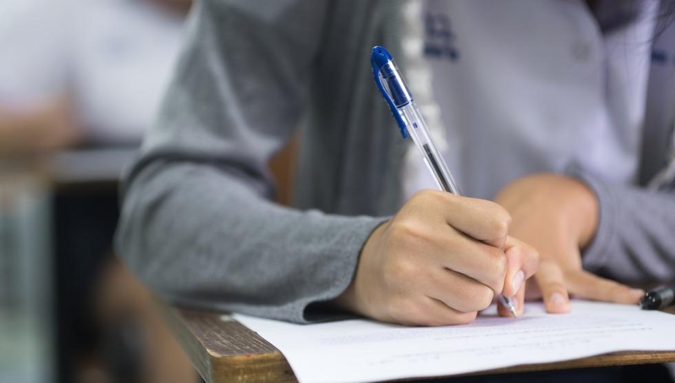 Pessoa resolve prova de concurso público.