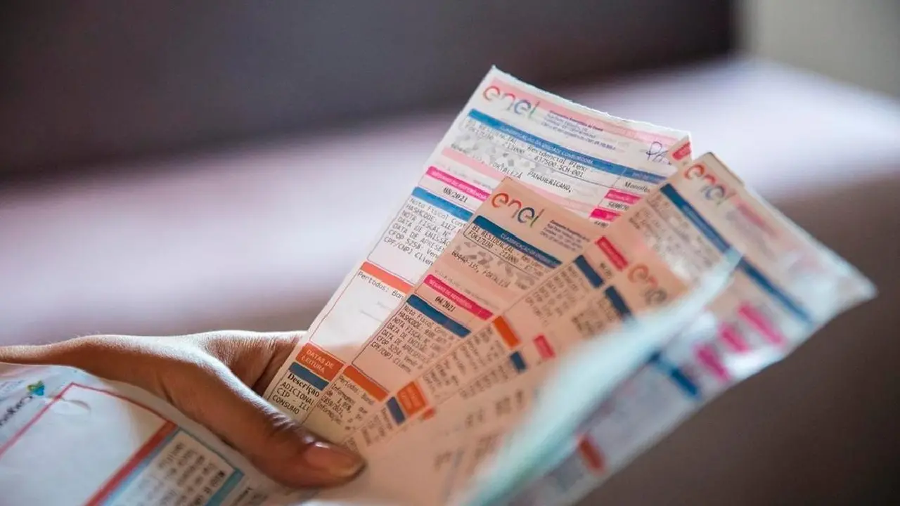 Mãos segurando contas de energia.