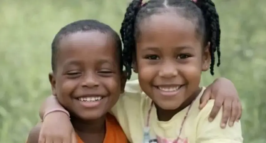 Crianças desaparecidas em região de mata no Maranhão. Ambas são negras, o menino com cabelo ralo e a menina com cabelo amarrado de ambos os lados. Ele usa uma blusa laranja e ela usa uma blusa amarela.