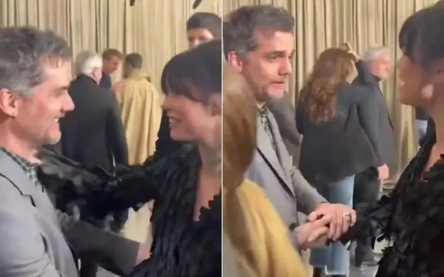 foto de Mia Goth e Wagner Moura interagindo durante conversa nos bastidores do desfile da Dior, durante a Semana de Moda de Paris, na França.