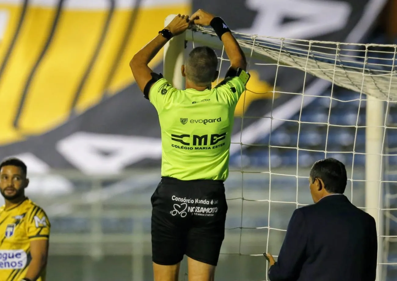 Árbitro Marcelo de Lima Henrique conserta rede pouco antes de Tirol x Ceará.