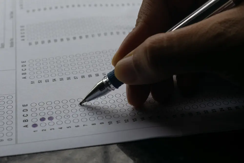 foto de candidato preenchendo gabarito de prova com caneta azul.