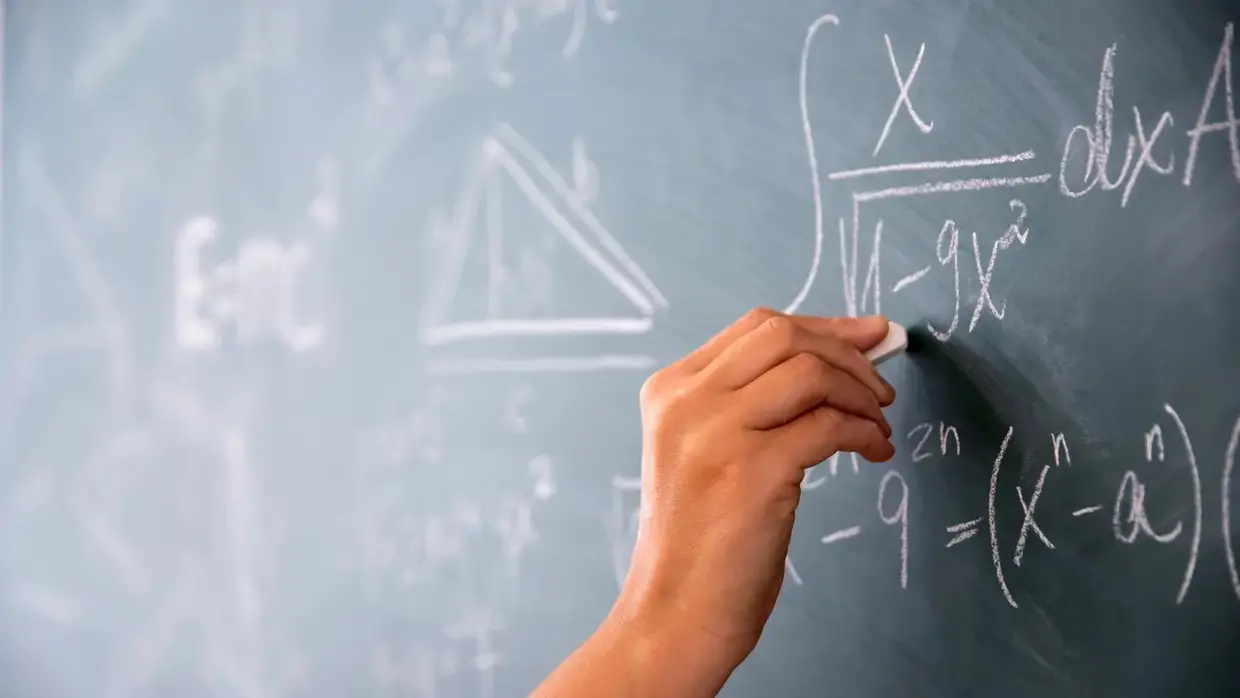 Professor escrevendo no quadro negro.