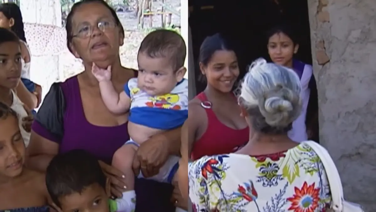 Cena comunitária ou familiar mostrando crianças, jovens e idosas, com um foco na mulher que segura o bebê e a interação entre as mulheres.