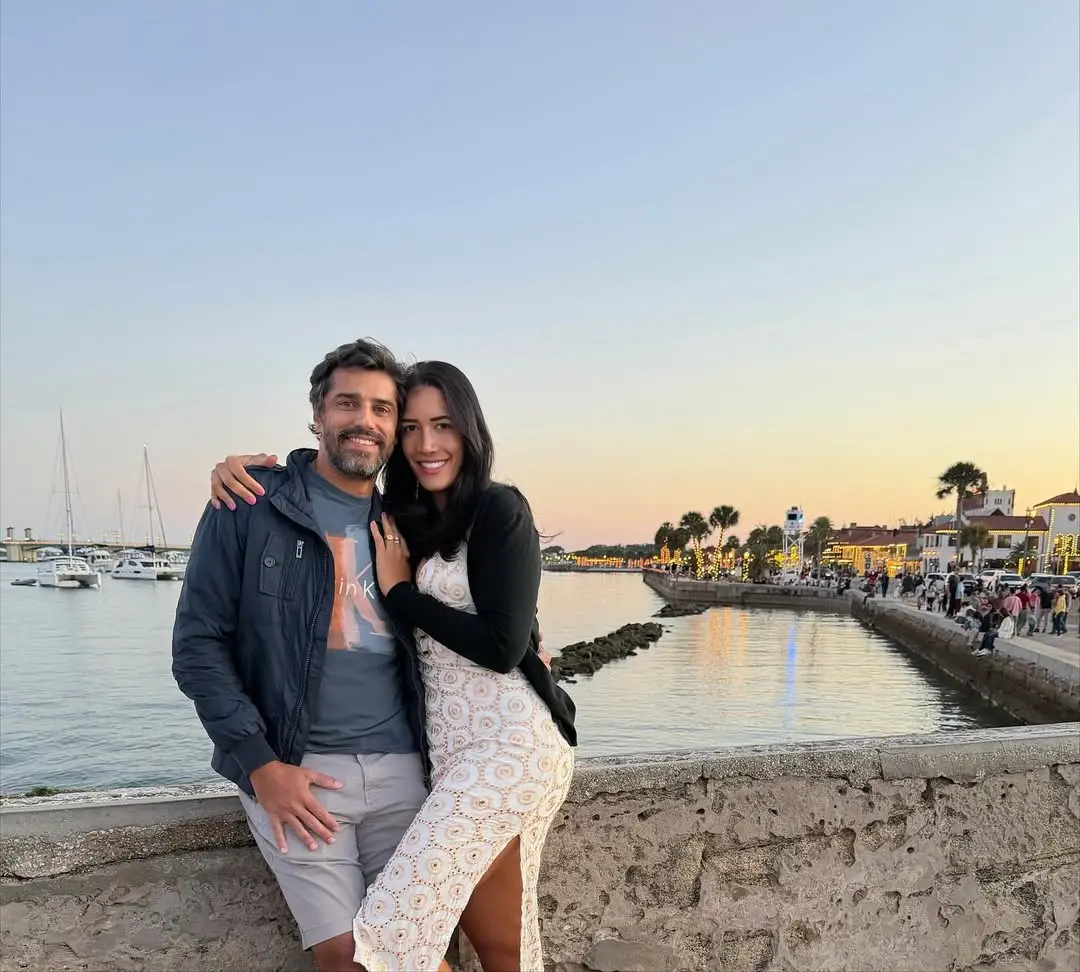 Priscilla e Cowboy posam para foto sobre ponte de rio.