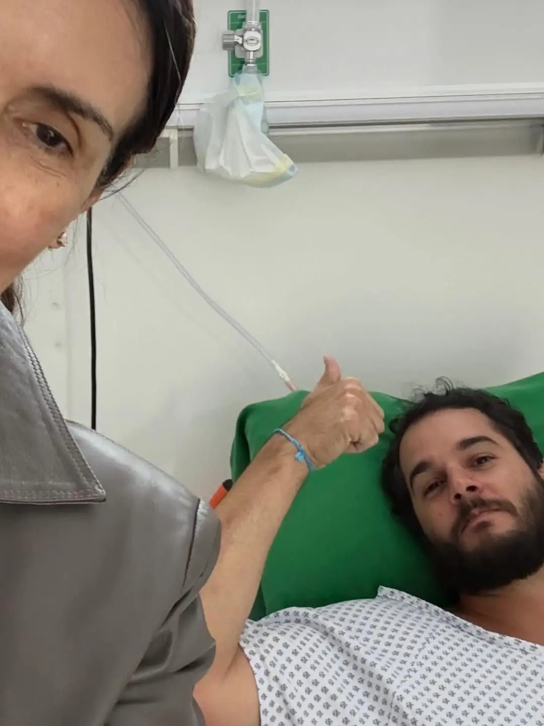 Túlio Gadêlha deitado em uma cama de hospitalar, com roupa hospitalar, explicou nas redes sociais que precisou ser internado.