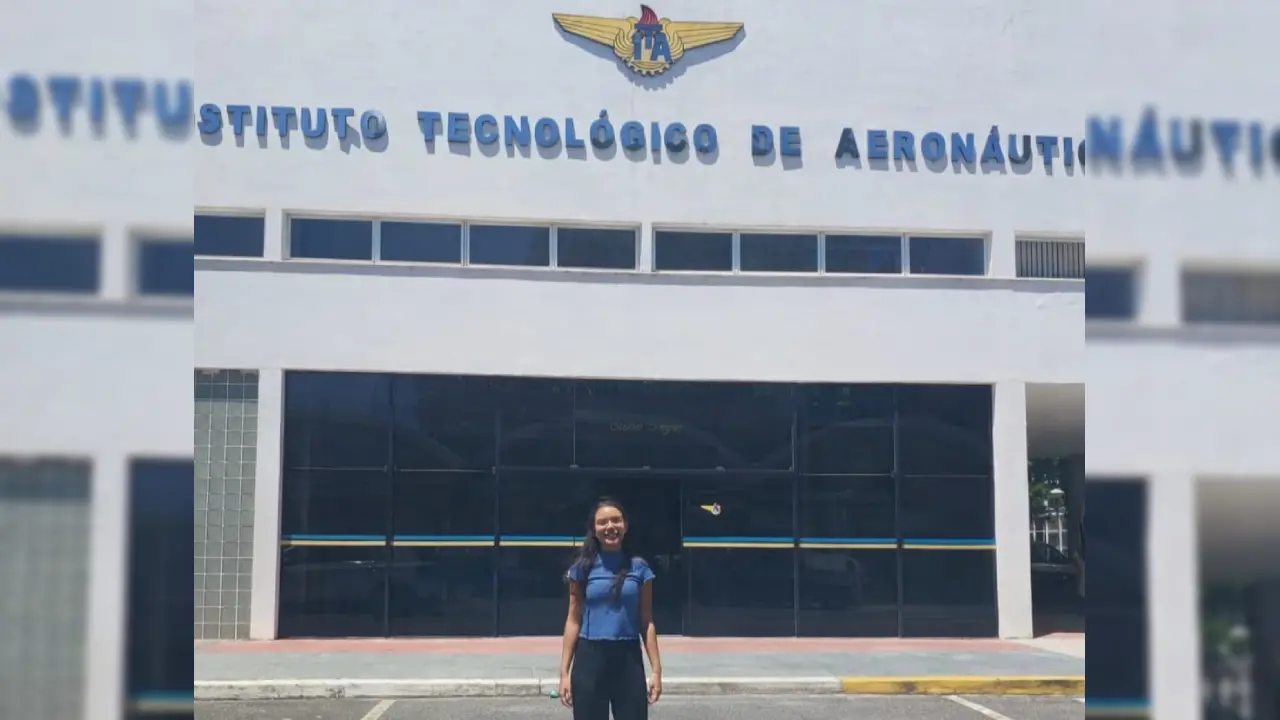Imagem mostra estudante jovem em frente ao prédio do Instituto Tecnológico de Aeronáutica, o ITA, em São Paulo.