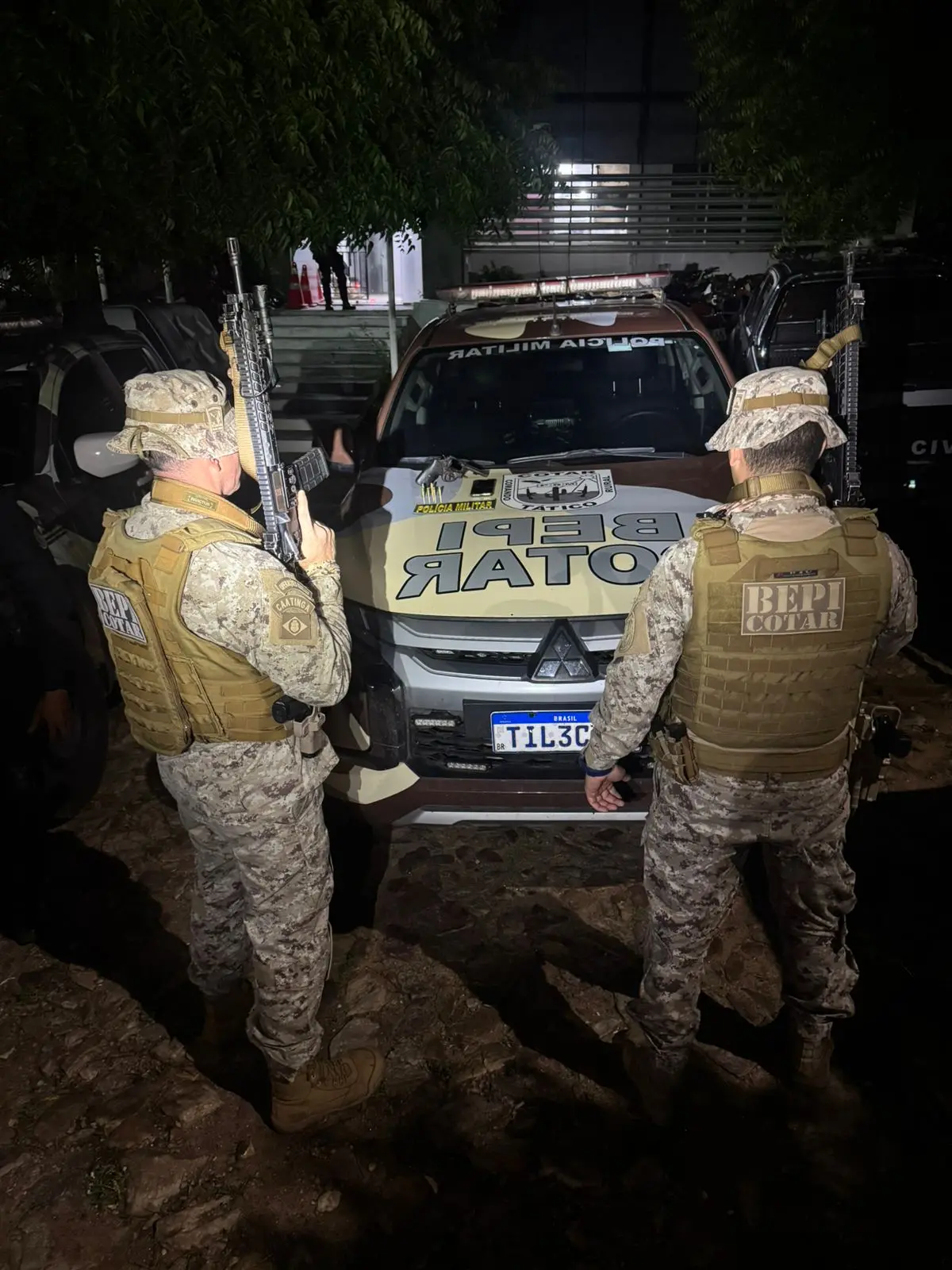 dois pms com farda, bepi, segurando armas.