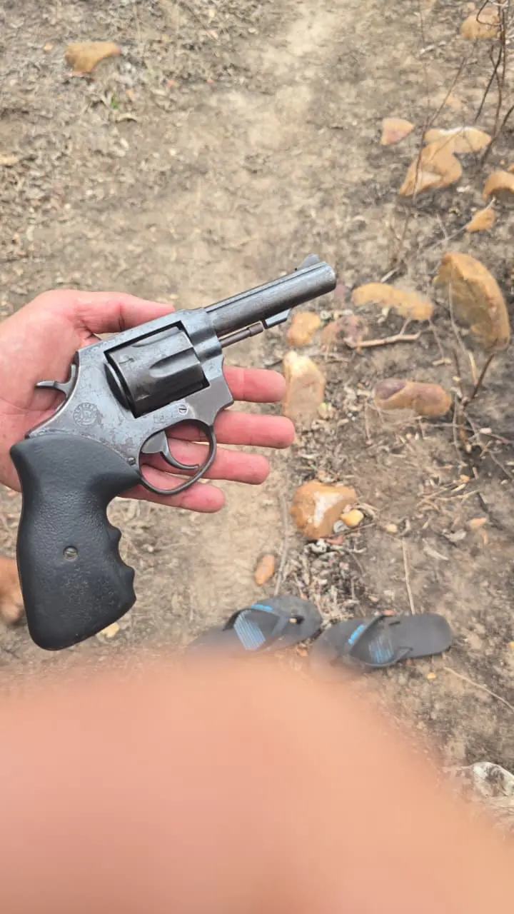 arma apreendida mao de pm segurando.