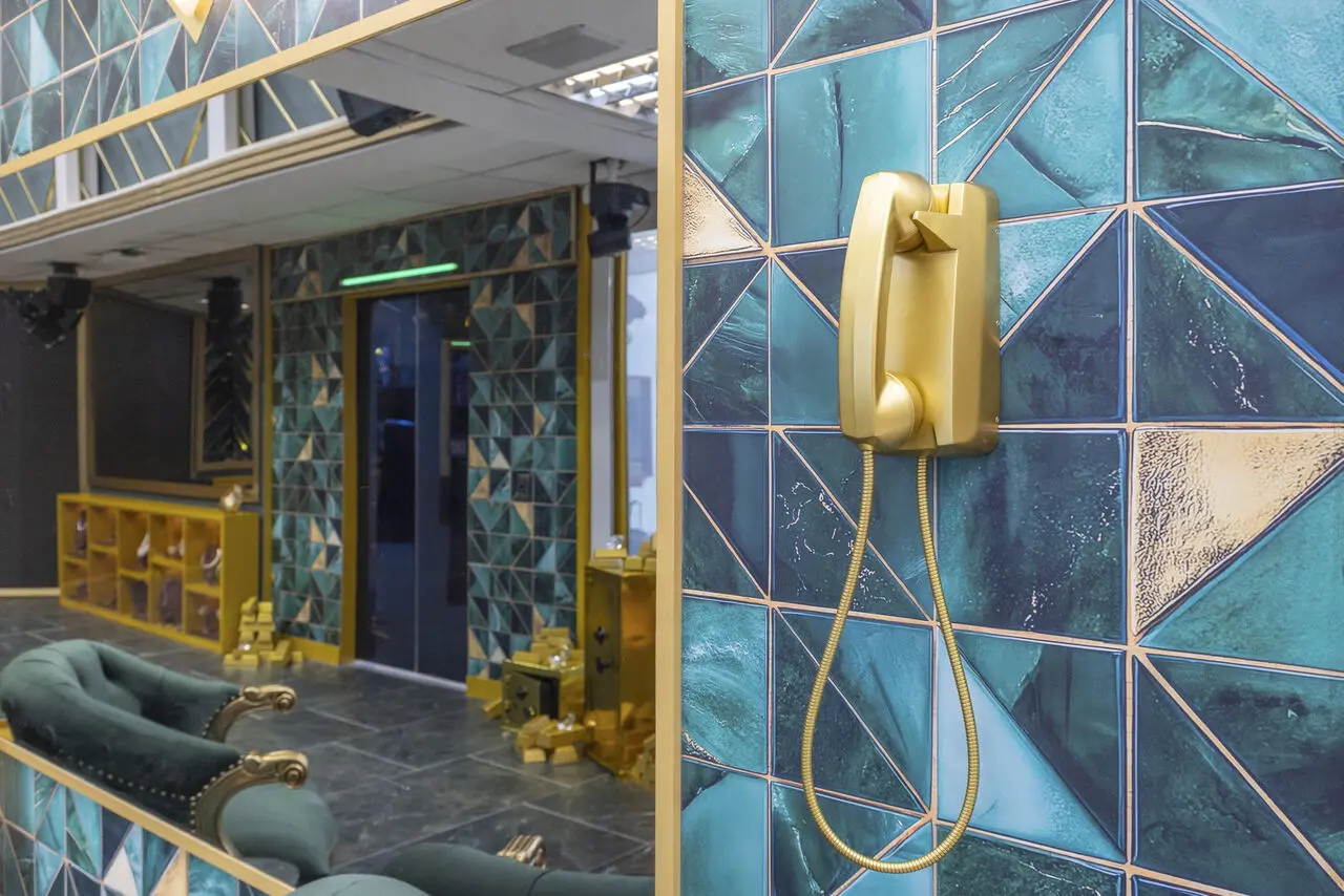 Imagem de telefone de fio dourado em parede azul