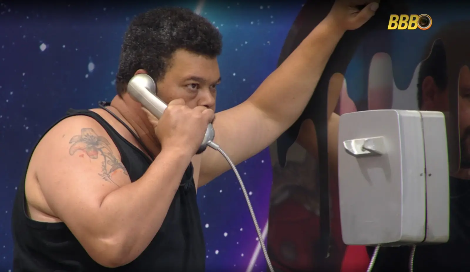 Imagem mostra Babu atendendo o big fone prata no BBB 26.