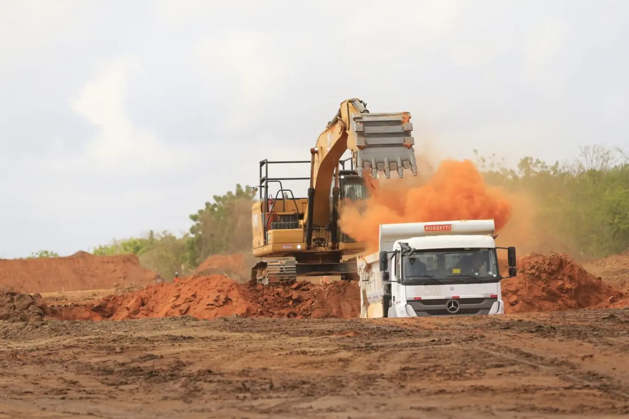 Imagem de dois caminhões em atividade de terraplanagem na execução das obras da ferrovia Transnordestina no Ceará.