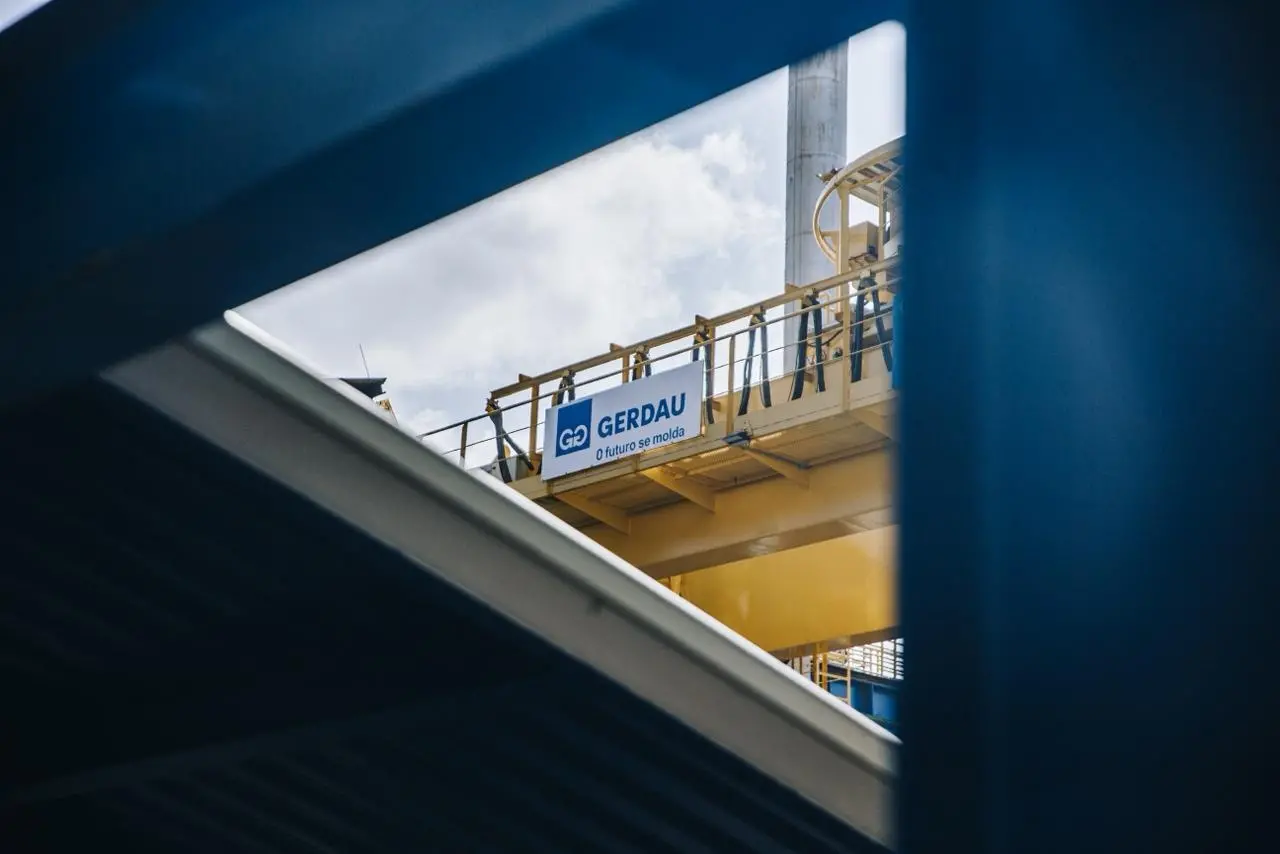 Estrutura industrial da siderúrgica da Gerdau, multinacional brasileira do aço, com placa da empresa em destaque.