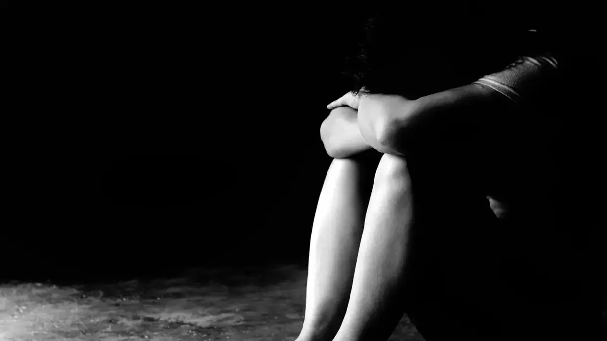 pes pernas braços foto preto e branco mulher sentada no chao, posicao de tristeza, defesa.