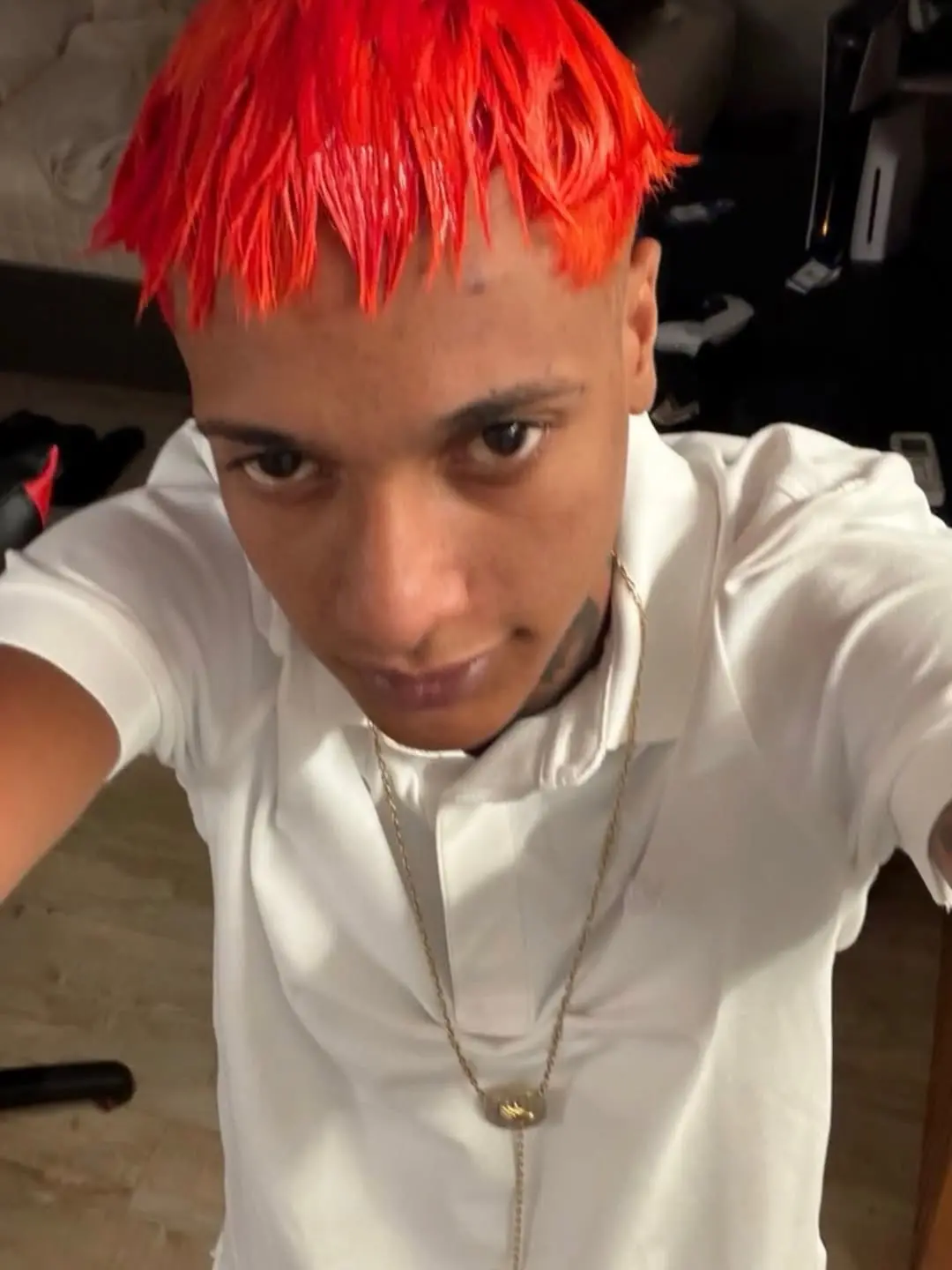 Imagem mostra rapper oruam de cabelo vermelho e roupa branca.